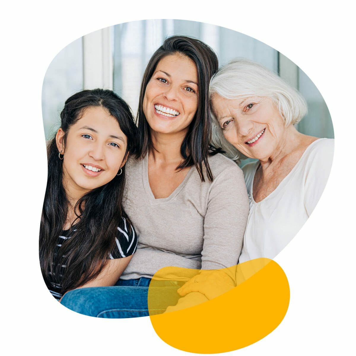 Three generations of women, daughter, mother and grandmother, sitting together, smiling and looking at the camera